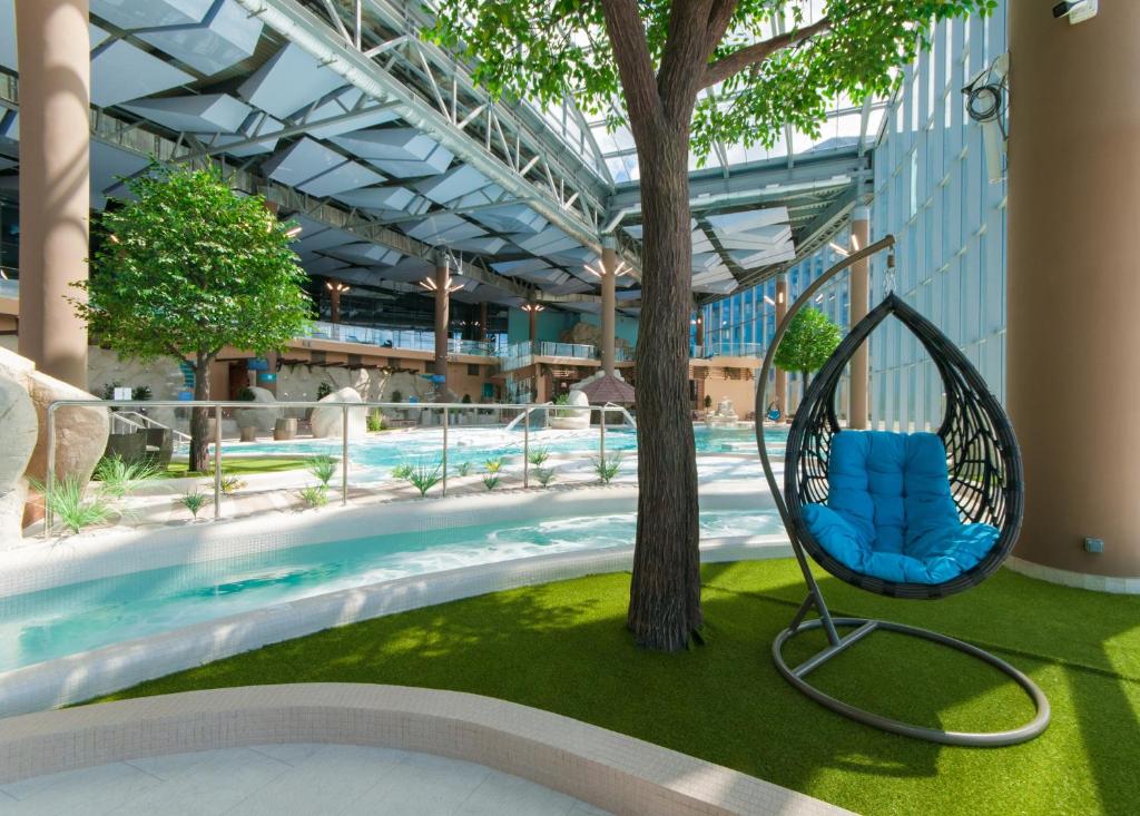 a swing hanging from a tree next to a pool at Марциаль in Tyumen