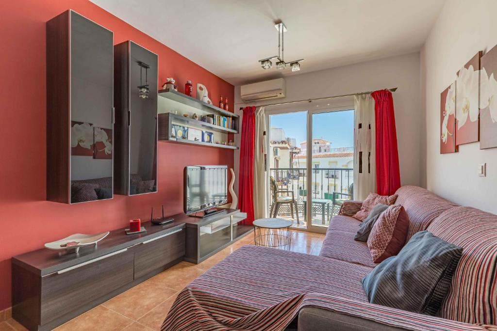 a living room with a couch and a flat screen tv at Apartamento Steffi - Centro de Nerja in Nerja