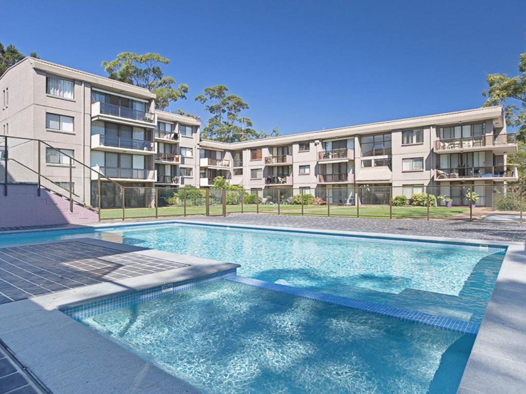 a swimming pool in front of a apartment building at The Poplars, 15,36 Magnus Street - Unit in a great complex with a pool and close to town in Nelson Bay