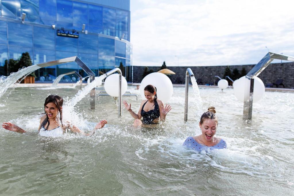 three girls playing in the water at a pool at Марциаль in Tyumen