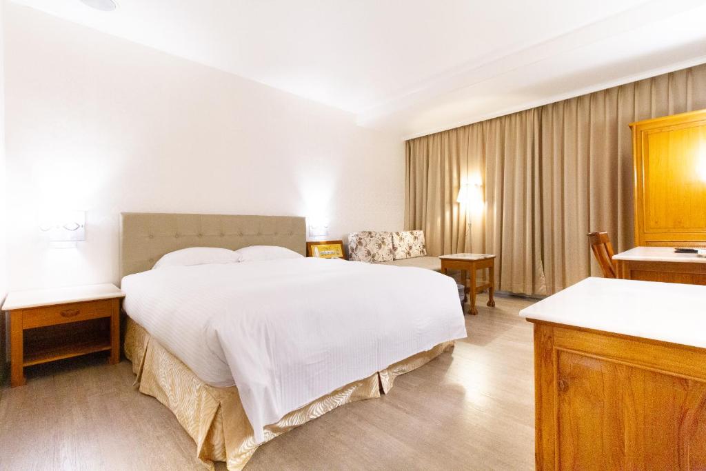 1 dormitorio con 1 cama blanca grande en una habitación en Daniel Motel en Xinying