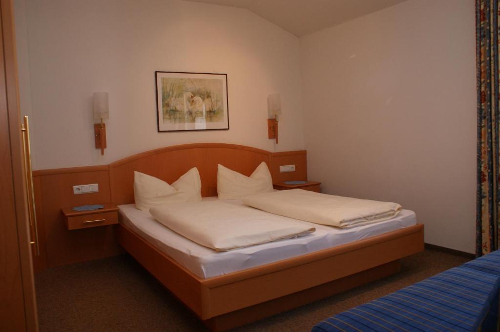Postel nebo postele na pokoji v ubytování Hotel Garni Jennewein