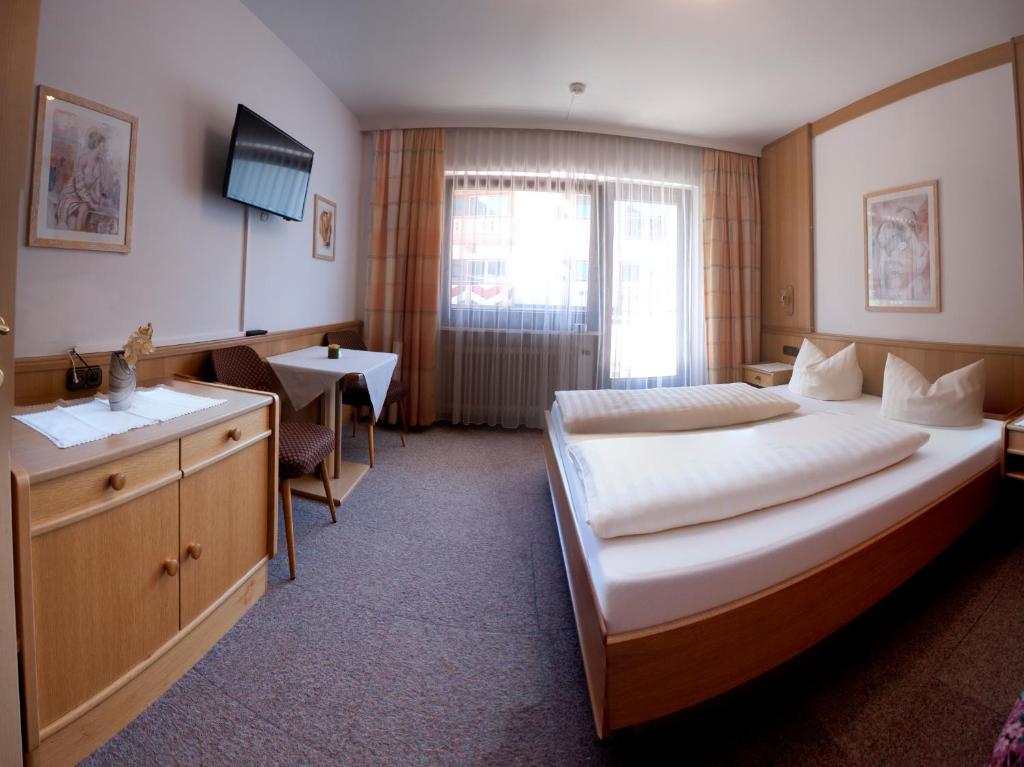 Postel nebo postele na pokoji v ubytování Hotel Garni Jennewein