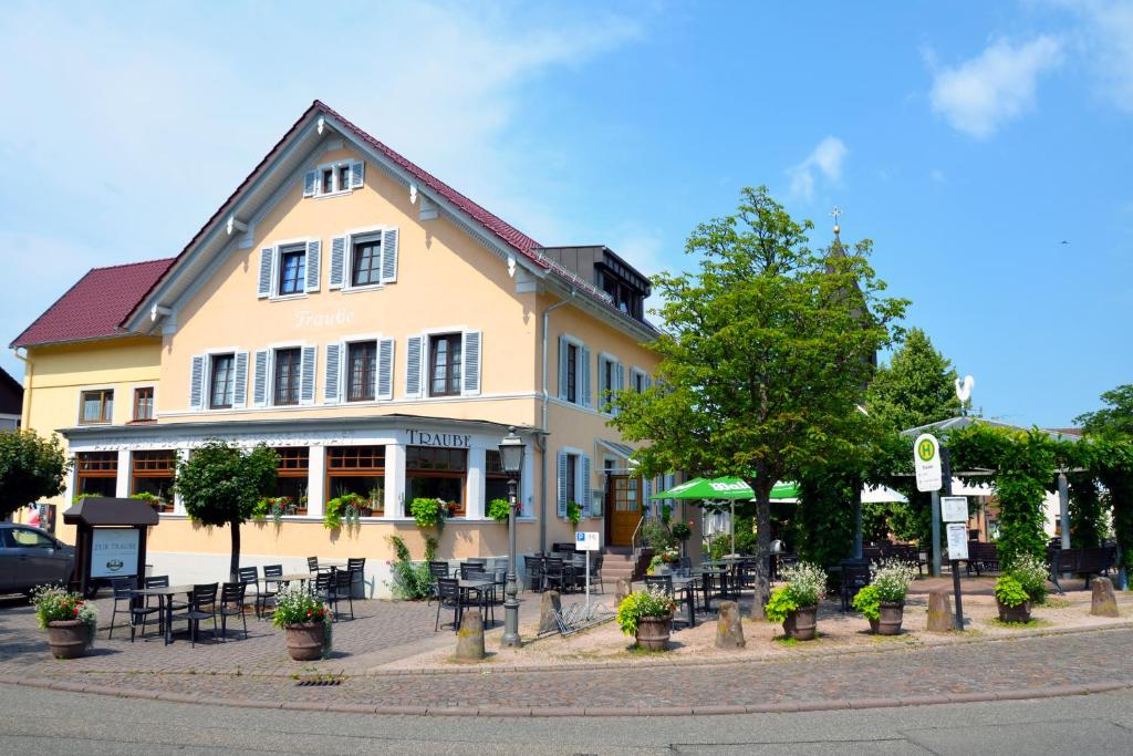un edificio con mesas y sillas delante de él en Gasthof zur Traube, en Bühl
