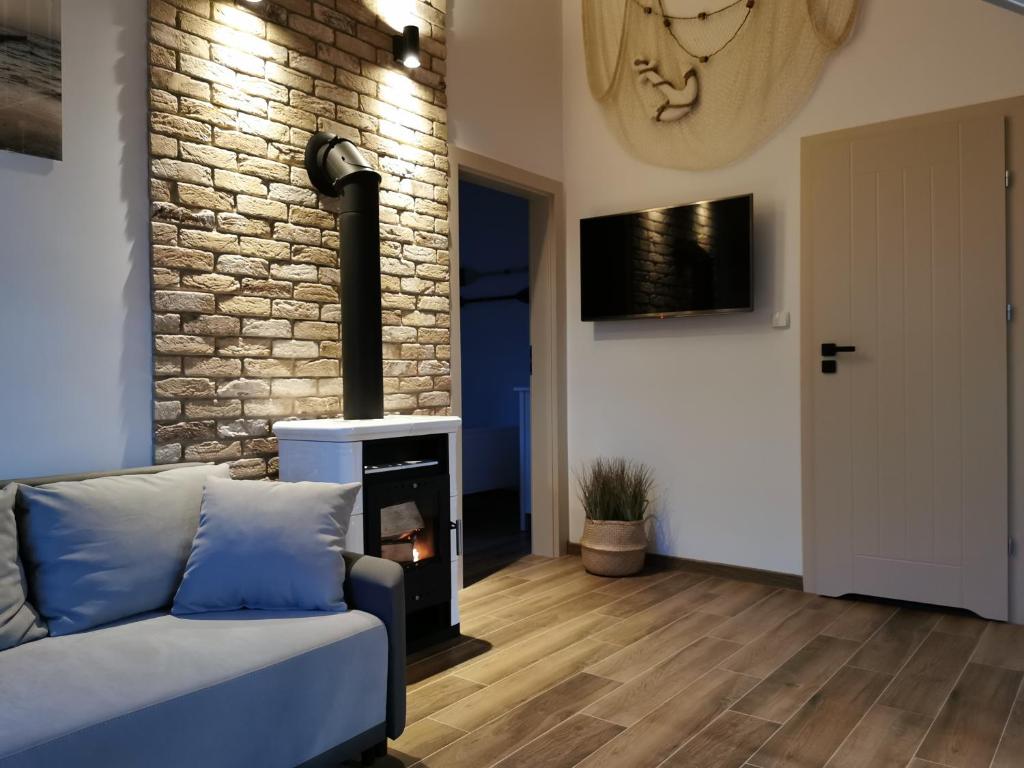 a living room with a couch and a fireplace at Zielone Miejsce in Karwia