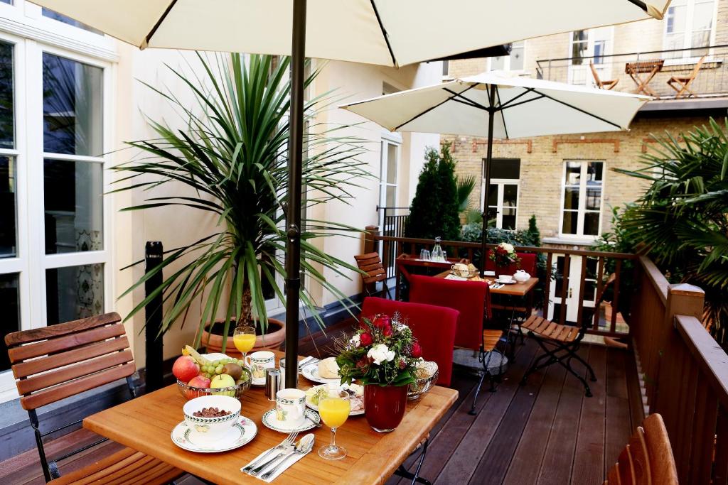 een houten tafel met eten en drinken op een patio bij Garden Living - Boutique Hotel in Berlijn
