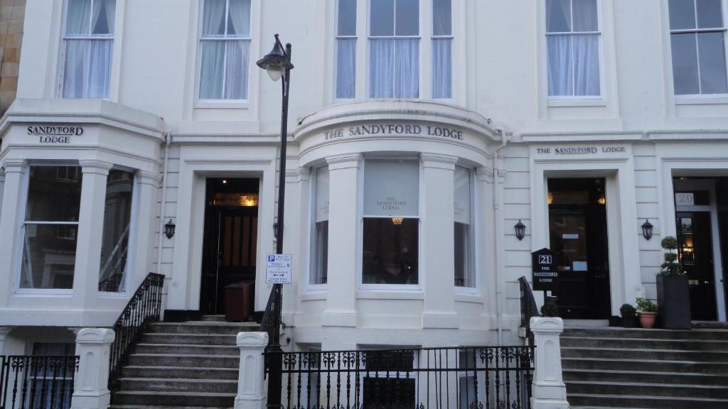 a white building with stairs in front of it at Sandyford Lodge in Glasgow