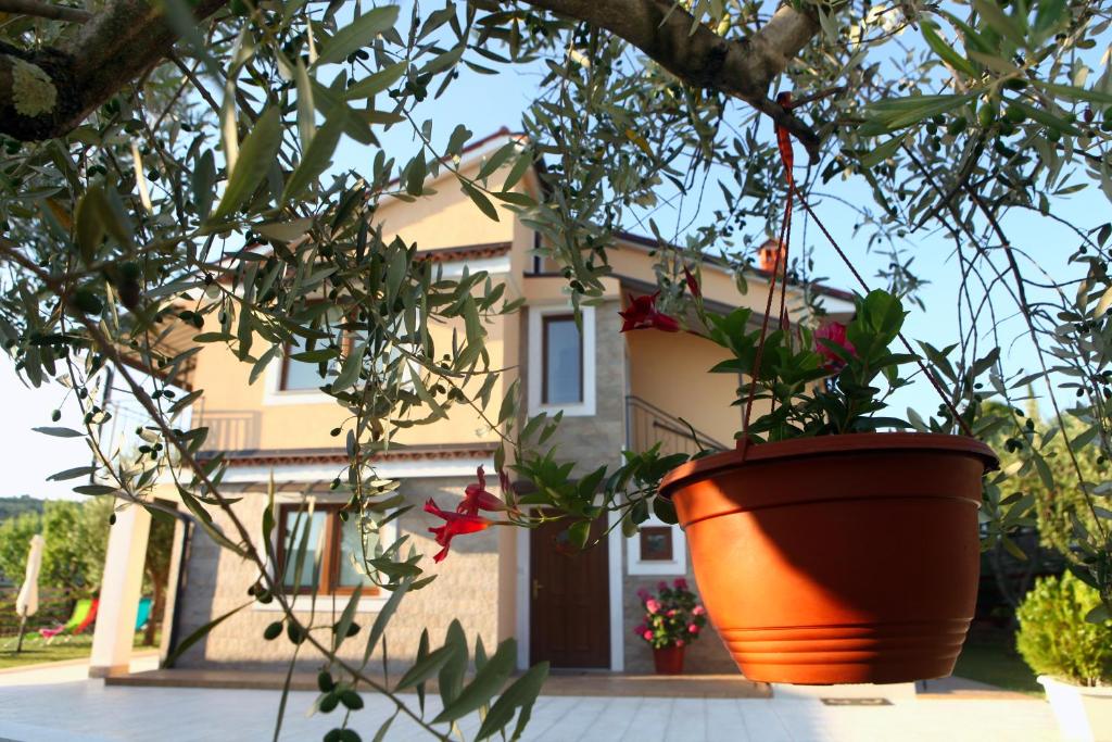 una maceta naranja frente a una casa en Residence Villa Fiore Portorož, en Portorož