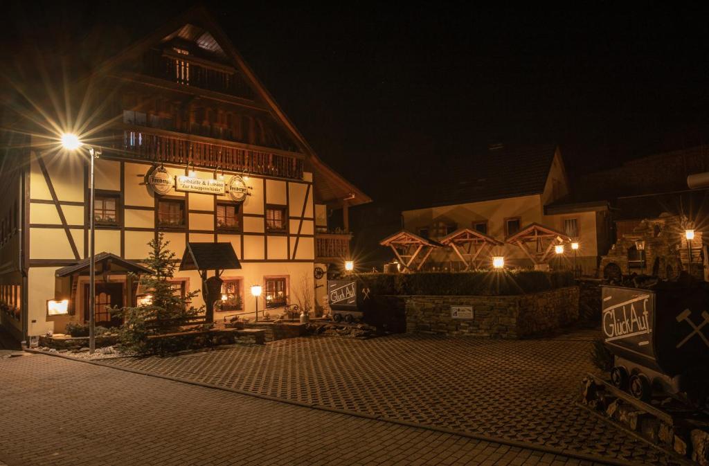 ein Gebäude in der Nacht mit Lichtern in der Unterkunft Pension und Gaststätte Zur Knappenschänke in Wiesa