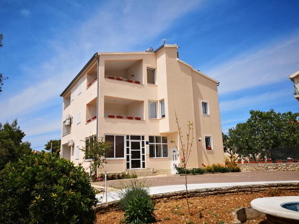 un gran edificio blanco al lado de una carretera en Apartments Villa Korina, en Brodarica