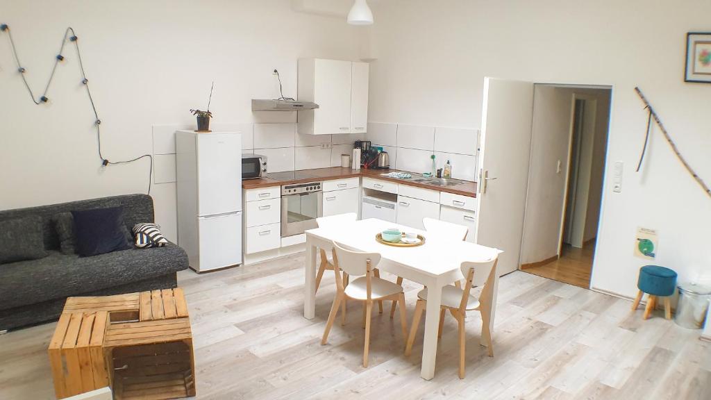 ein Wohnzimmer mit einem Tisch und einer Küche in der Unterkunft Big Appartment near trade fair! in Köln