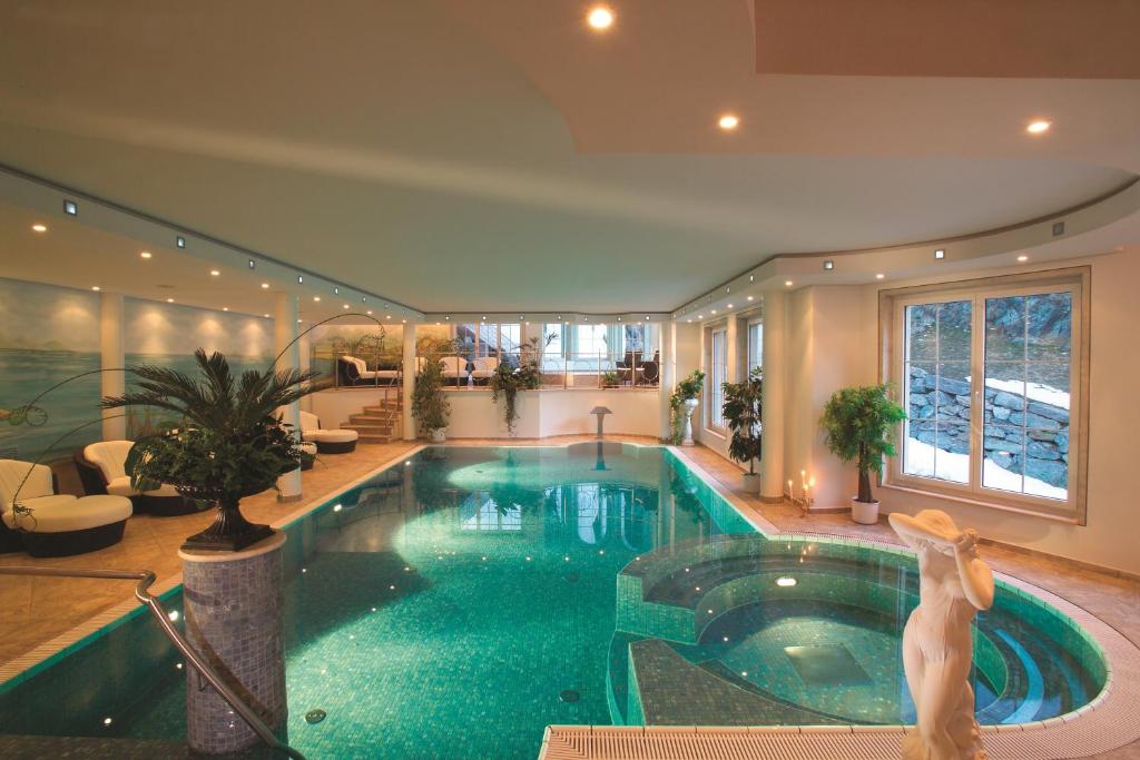 - une grande piscine dans une maison avec une piscine dans l'établissement Hotel Sonne, à Zermatt