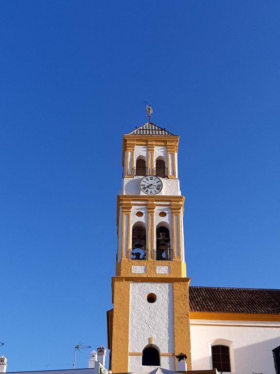 una torre de reloj en la parte superior de un edificio en Precioso y acogedor ático old town, en Marbella
