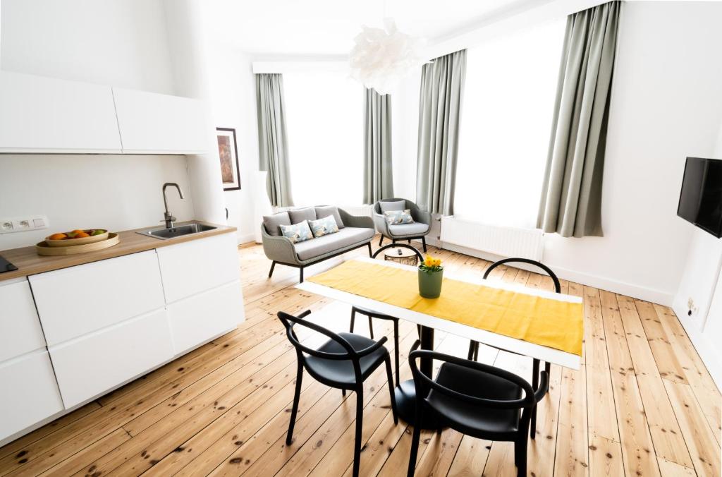 eine Küche und ein Wohnzimmer mit einem Tisch und Stühlen in der Unterkunft FLATS - Résidence D'ici D'ailleurs in Brüssel