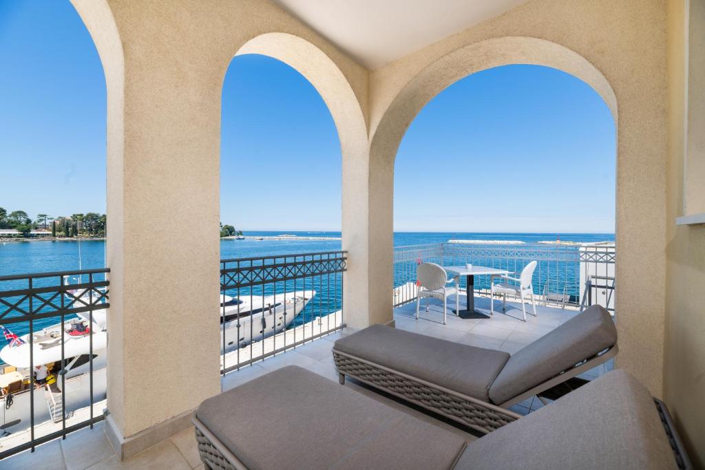 a balcony with chairs and a view of the water at BO Hotel Palazzo in Poreč