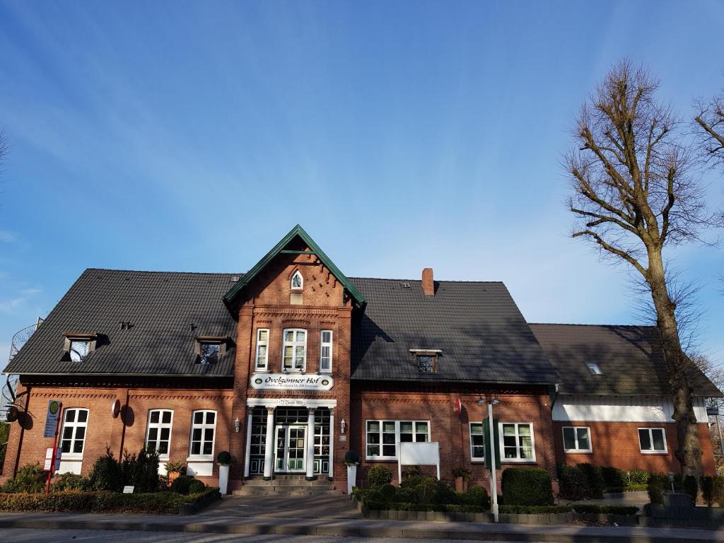 ein rotes Backsteingebäude mit schwarzem Dach in der Unterkunft Ovelgönner Hof in Buxtehude