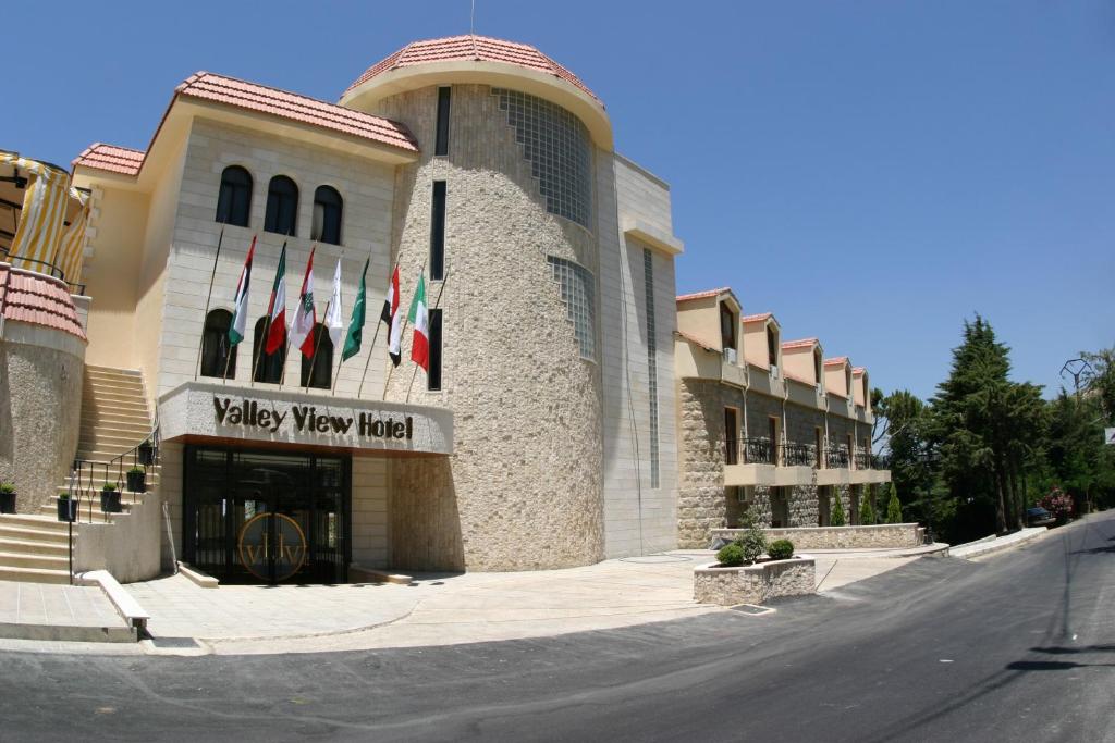 a view of a building with flags in front of it at Valley View Hotel - Hammana in Ḩammānā