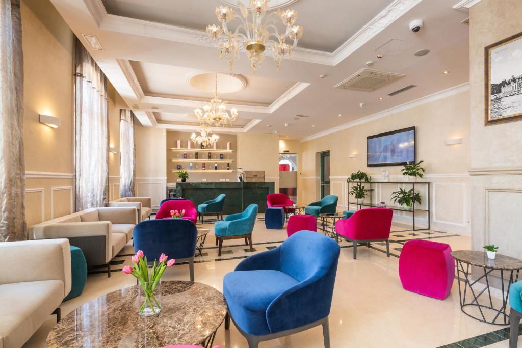 a waiting room with colorful chairs and tables at BO Hotel Palazzo in Poreč