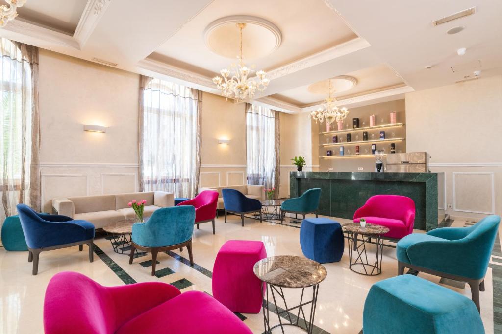 a waiting room with colorful chairs and tables at BO Hotel Palazzo in Poreč