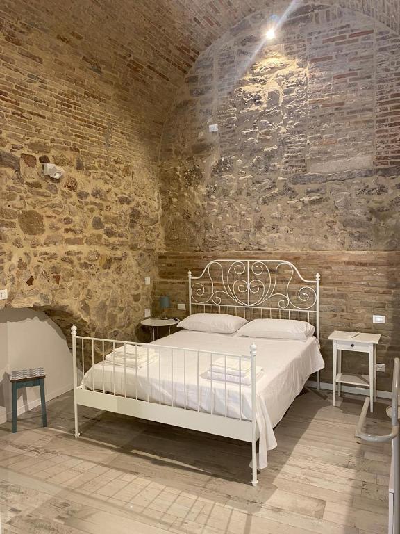 a bedroom with a white bed in a brick wall at Le volte nel borgo in Termoli