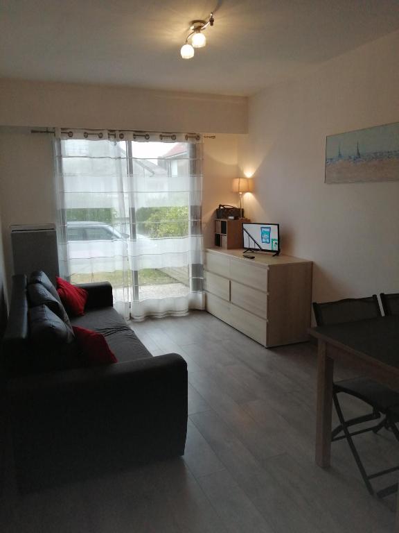 un salon avec un canapé et une télévision dans l'établissement les voiliers, à Le Touquet-Paris-Plage