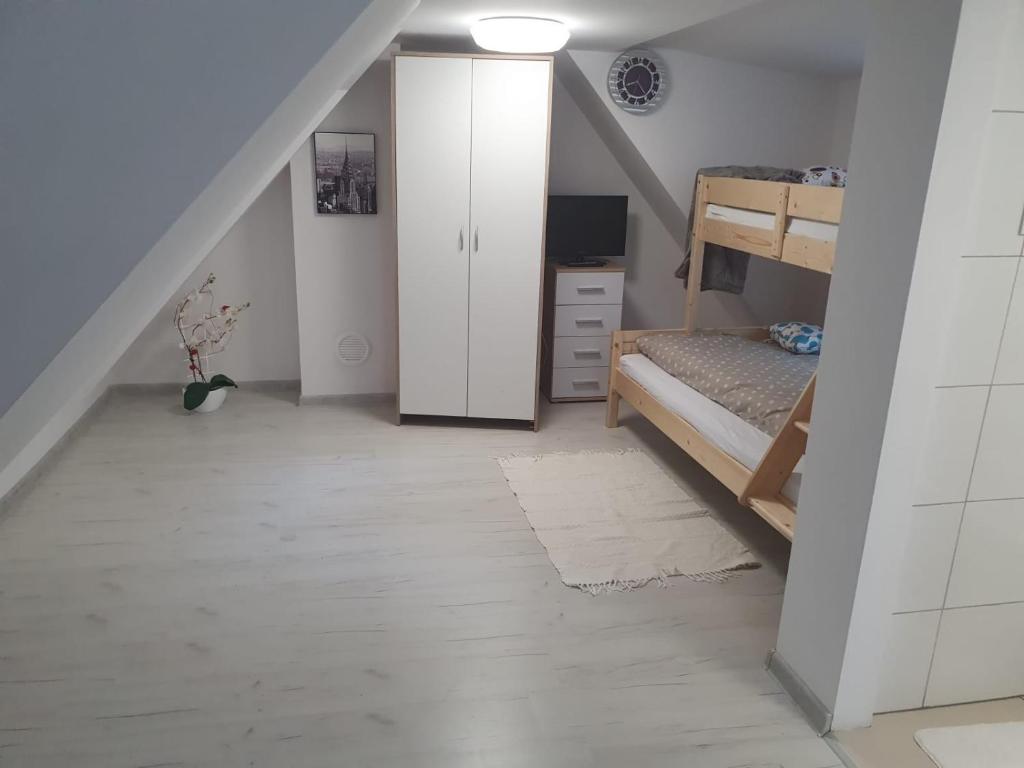 a attic room with a bunk bed and a closet at Chatka u Radka in Ustka