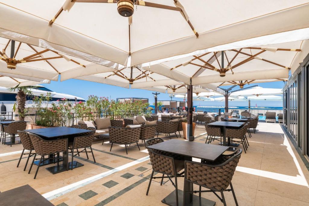 an outdoor patio with tables and chairs under umbrellas at BO Hotel Palazzo in Poreč