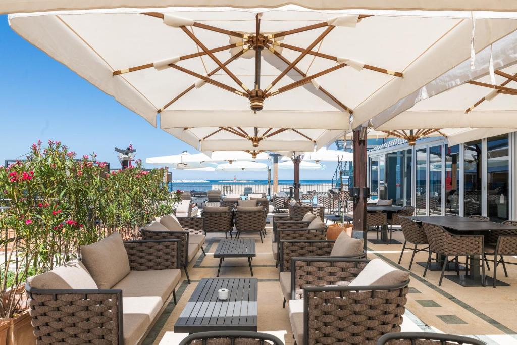 an outdoor patio with chairs and tables and umbrellas at BO Hotel Palazzo in Poreč