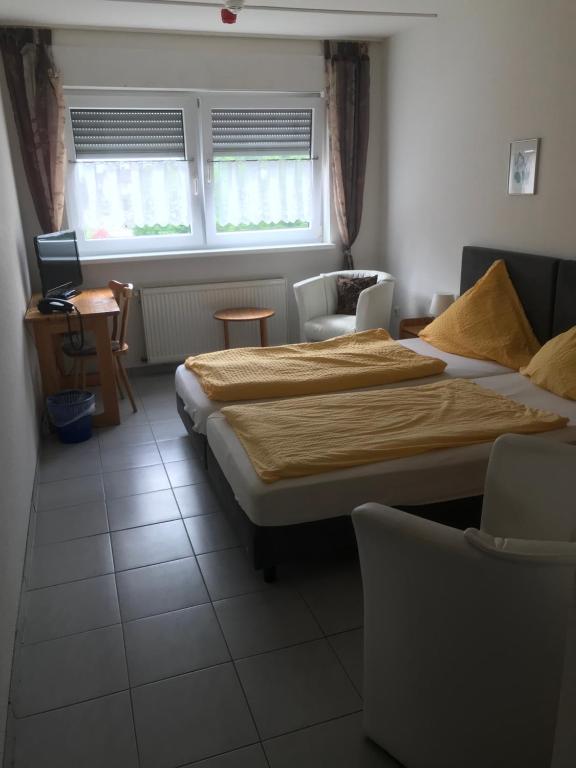 um quarto com uma cama, uma secretária e 2 janelas em Hotel Kaufmann em Rommerskirchen