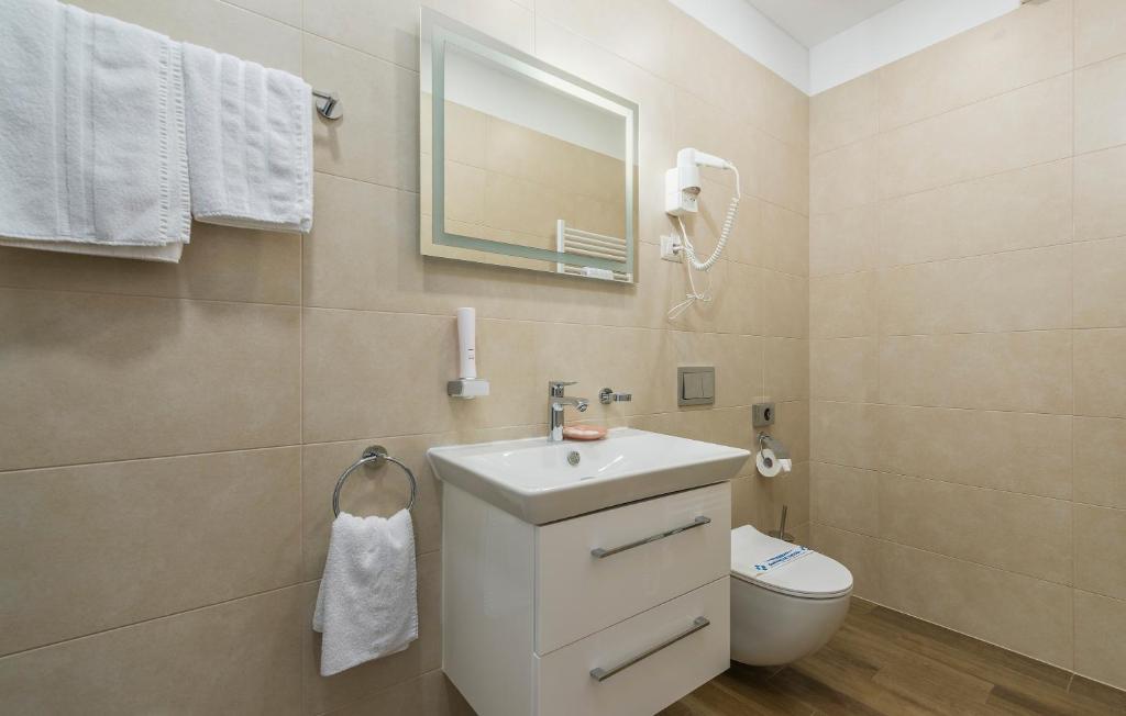 a bathroom with a sink and a toilet and a mirror at Boutique Hotel Melissa in Poreč