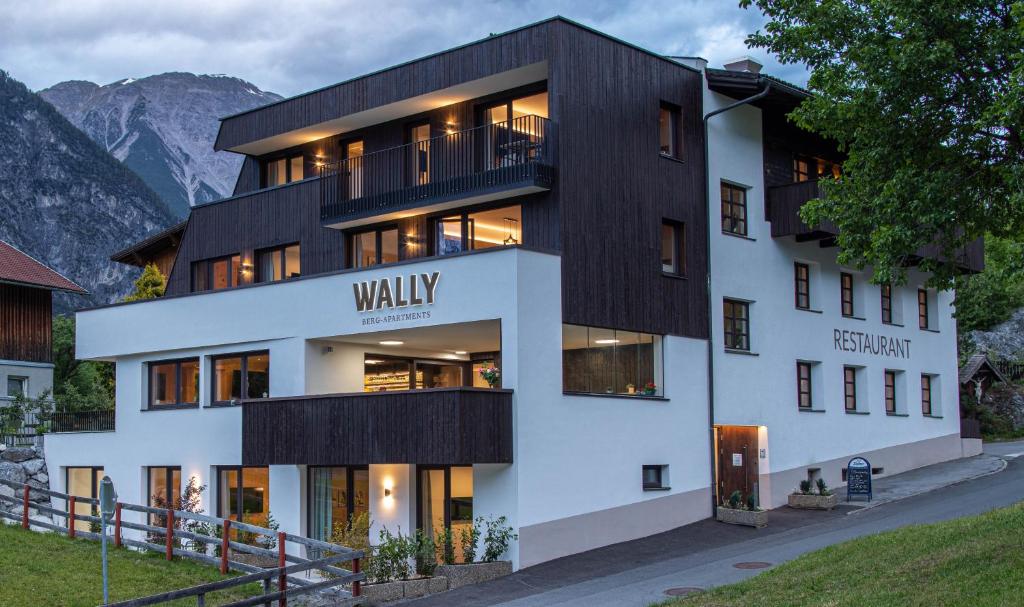 a building in the mountains with its lights on at Wally Berg-Appartements in Zams
