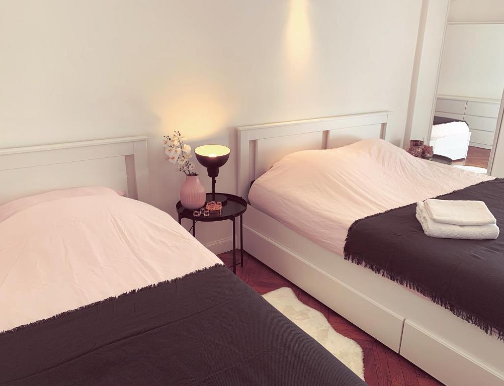 een slaapkamer met 2 bedden en een lamp op een tafel bij Big Bright New Apt next to Casino in Monte Carlo