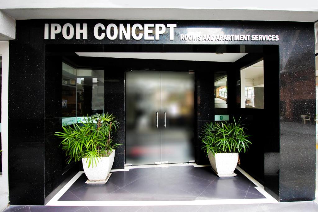 um edifício com dois vasos de plantas na frente de uma porta em Ipoh Concept Services em Ipoh