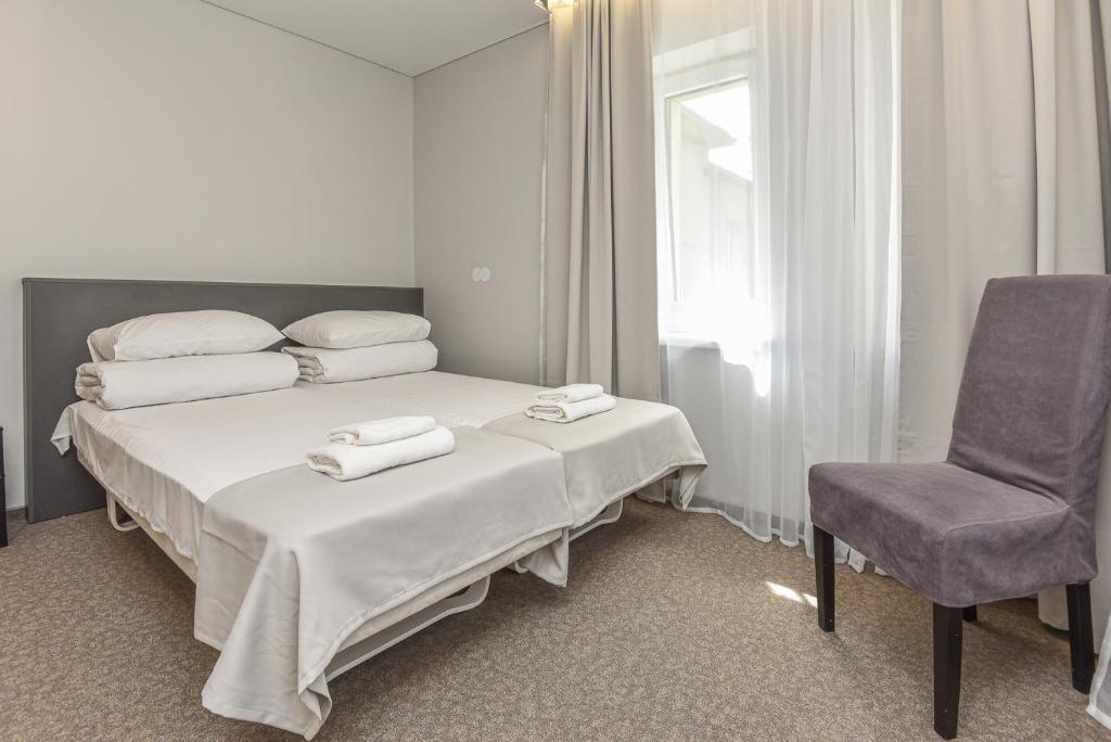 a hotel room with a bed and a chair at Palanga Centrum in Palanga