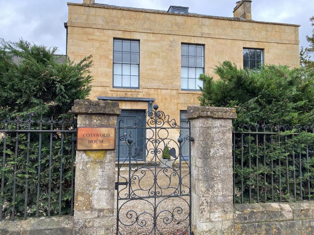 a gate to a house with a building behind it at Cotswold House in Moreton in Marsh