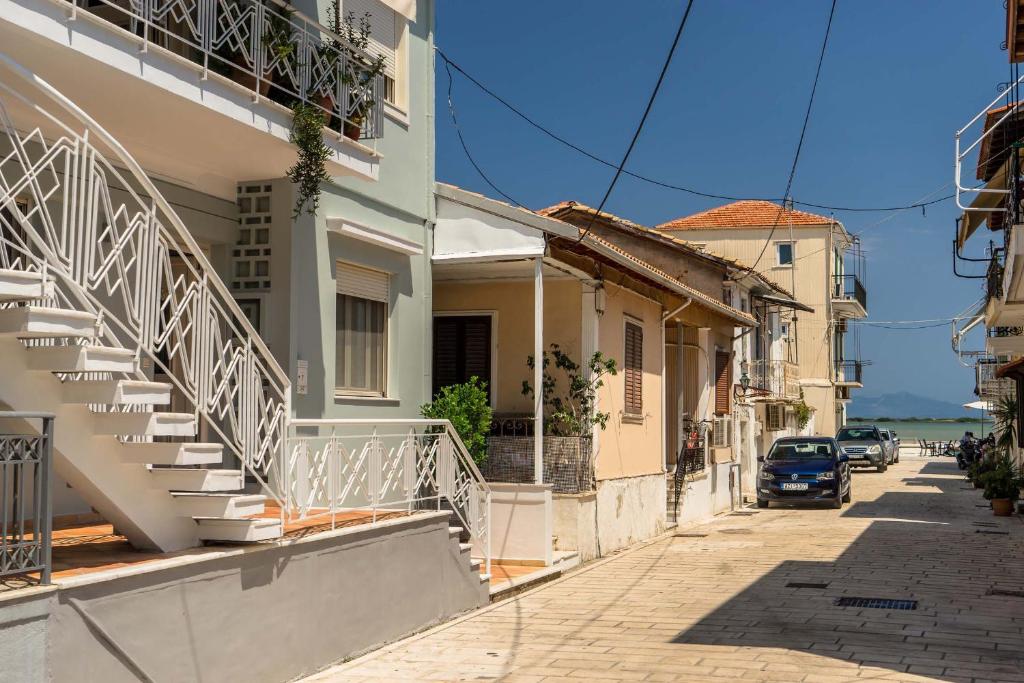 ulica z budynkiem ze schodami i samochodem w obiekcie THE STREET HOUSE w mieście Leukada (miasto)
