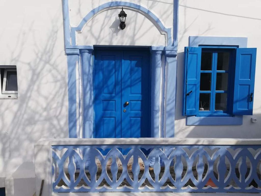 une porte bleue et une fenêtre sur un bâtiment dans l'établissement Villa Evdokia Kasos, à Agía Marína