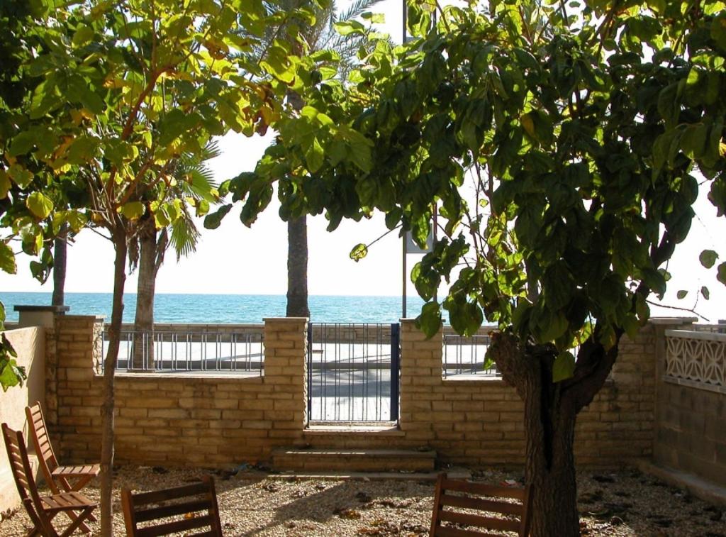 サロウにあるSalou 1 · House -garden in front of the beach - Ferrari Landの海を背景に木と椅子2脚