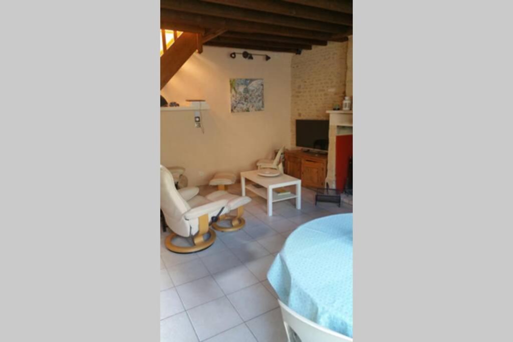 une chambre avec un lit, une chaise et une table dans l'établissement Maison de pêcheur, à Grandcamp-Maisy