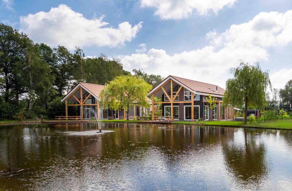 una casa con un estanque delante de ella en TopParken – Résidence Lichtenvoorde, en Lichtenvoorde