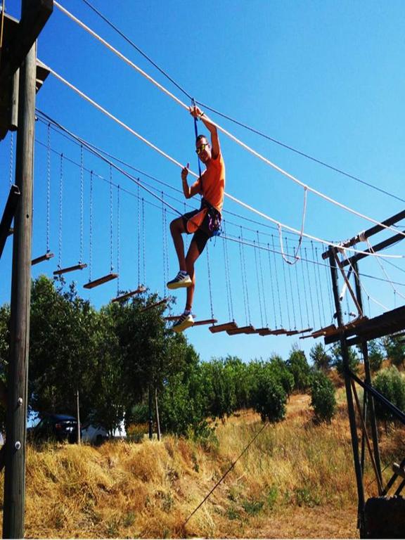 a man is jumping on a zip line at Complejo Pueblo Blanco in Olvera