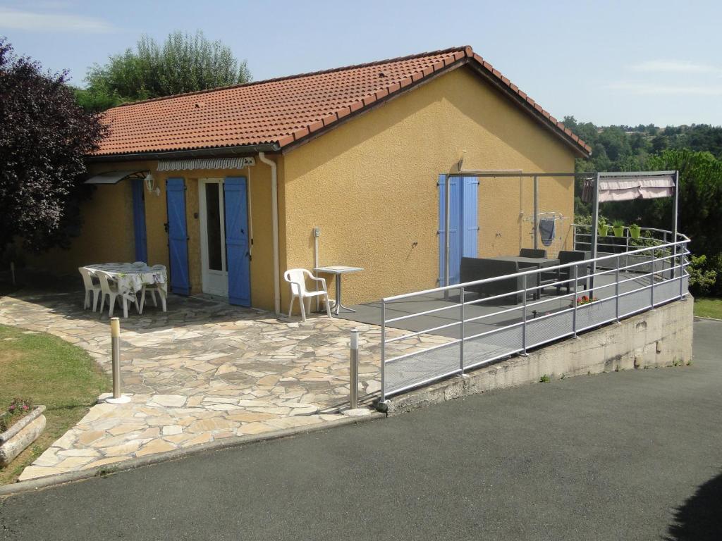 a small yellow house with a table and a patio at La Maison Provençale in Unieux