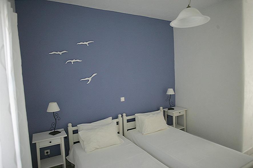 1 dormitorio con 2 camas con aves blancas en la pared en Villa Sophie, en Naousa