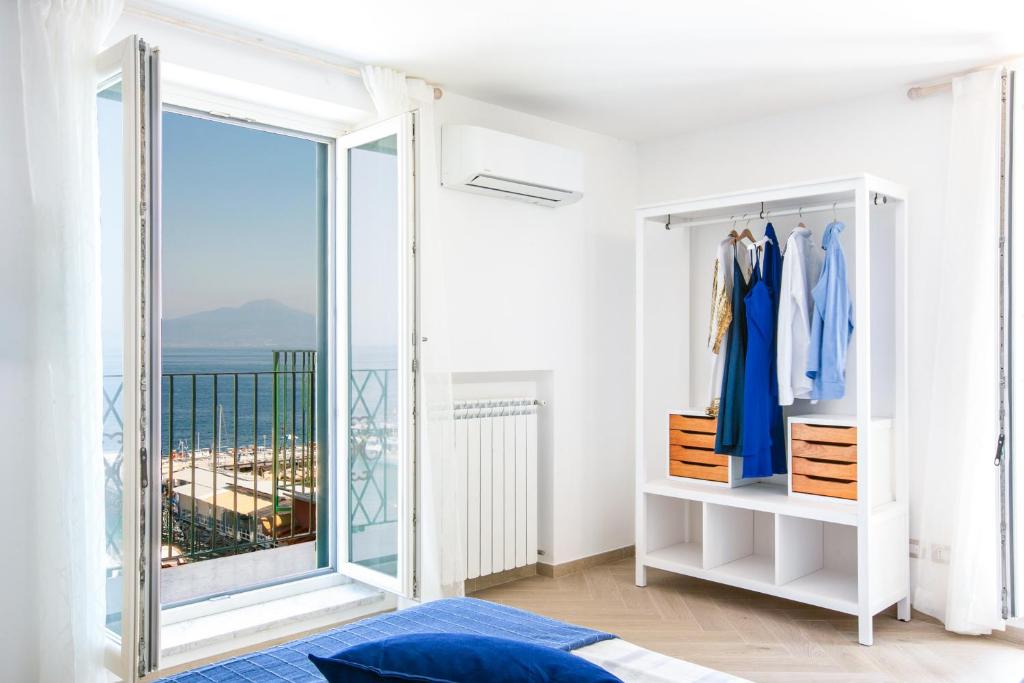 biały pokój z dużym oknem i garderobą w obiekcie SeaView Sorrento Apartment by the sea with terrace w Sorrento