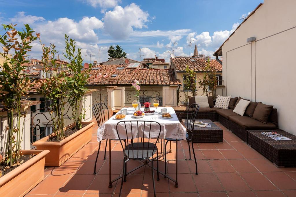 patio con mesa y sillas en el balcón en Attic Up On Florence, en Florencia
