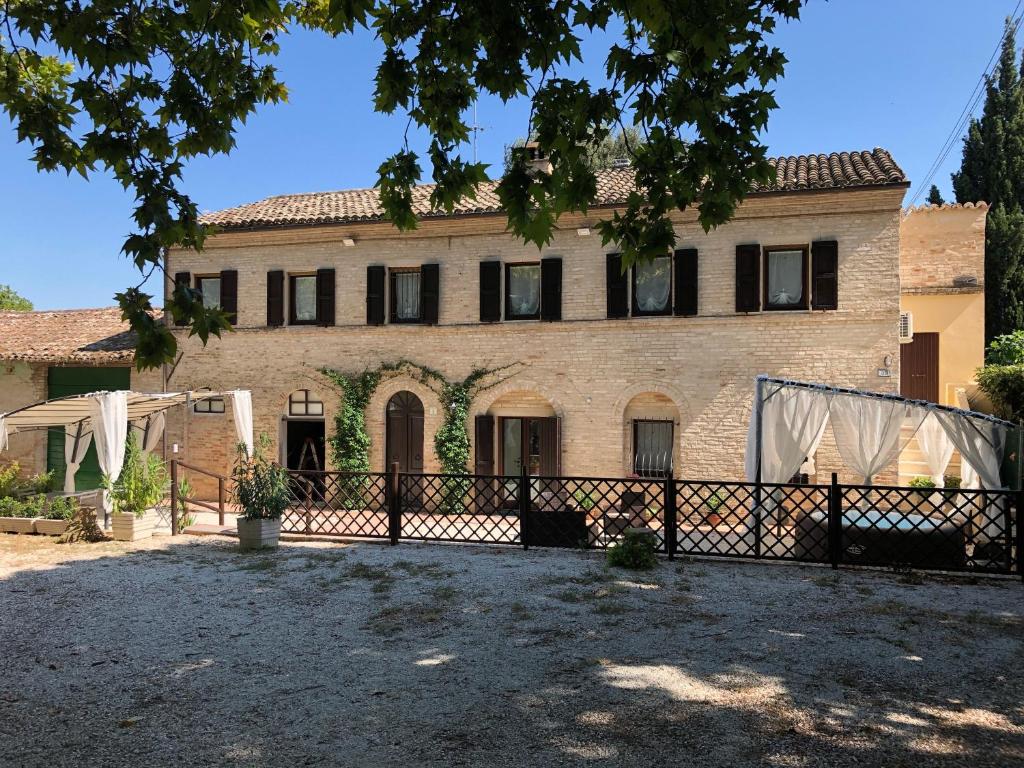 una gran casa de ladrillo con una valla delante de ella en prima dell'opera, en Macerata