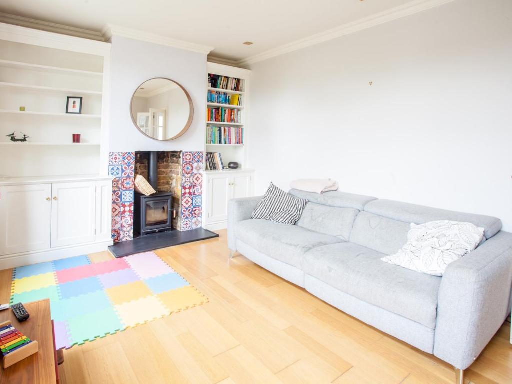 ein Wohnzimmer mit einem Sofa und einem Kamin in der Unterkunft Modern & Peaceful Family Home with Private Garden in London