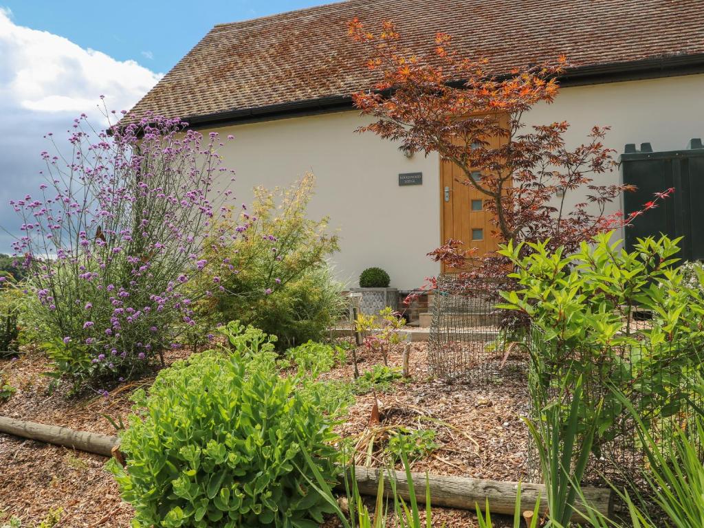 a garden in front of a house with flowers at Roughwood in Ringwood