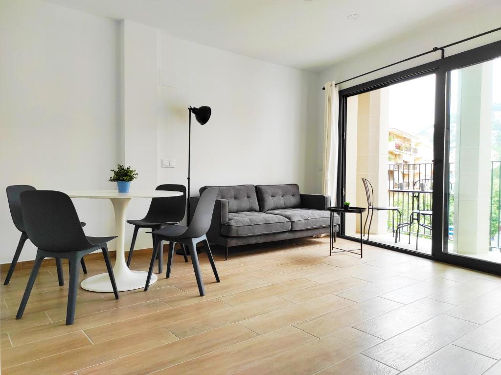a living room with a couch and a table and chairs at Aiguaneu El Celler in Blanes