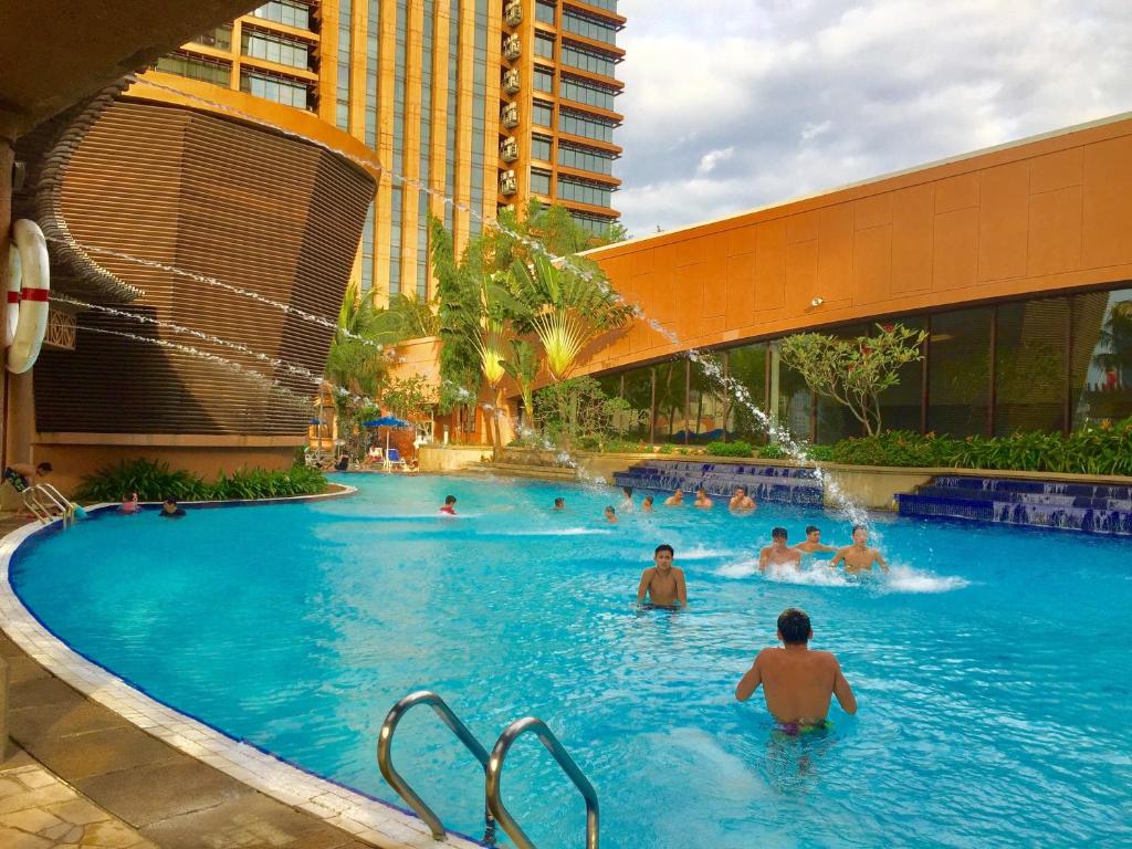 a group of people swimming in a swimming pool at Ni Hao Suites At Times Square in Kuala Lumpur